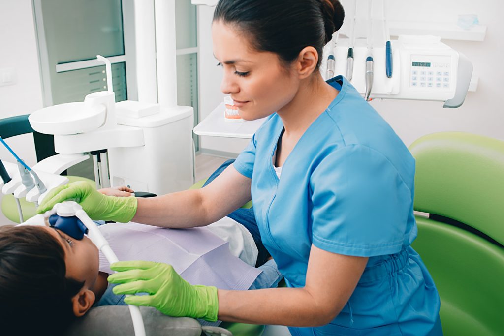 Dentist giving a child nitrous oxide for sedation dentistry