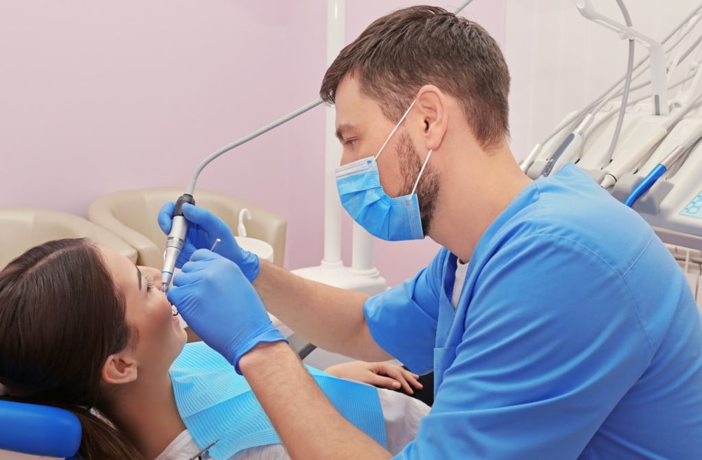 Dentist replacing a lost filling in a smiling patient's mouth