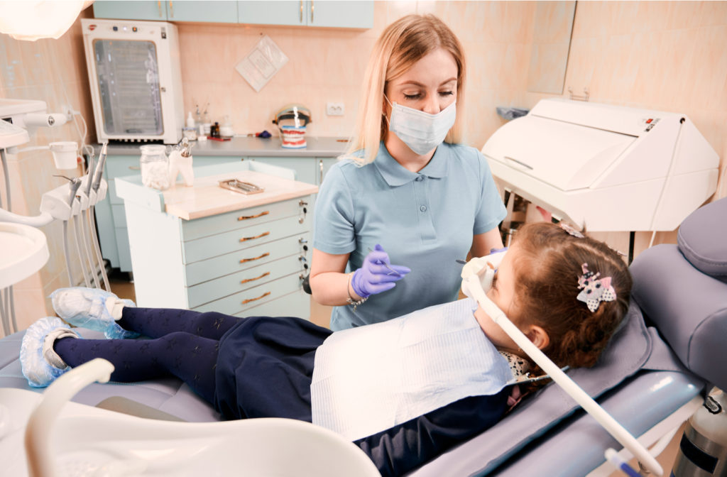 Child undergoing IV sedation at dental clinic by dentist to undergo dental surgery