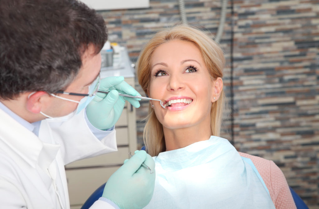 Women having teeth examined by dentist with instruments at dental clinic